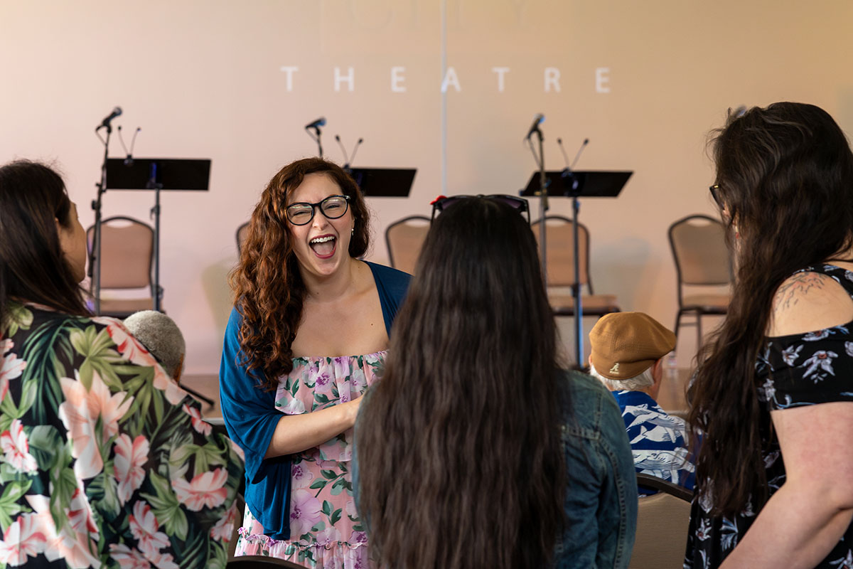 Gallery 4 - Young female playwright laughing with a group of other young women.